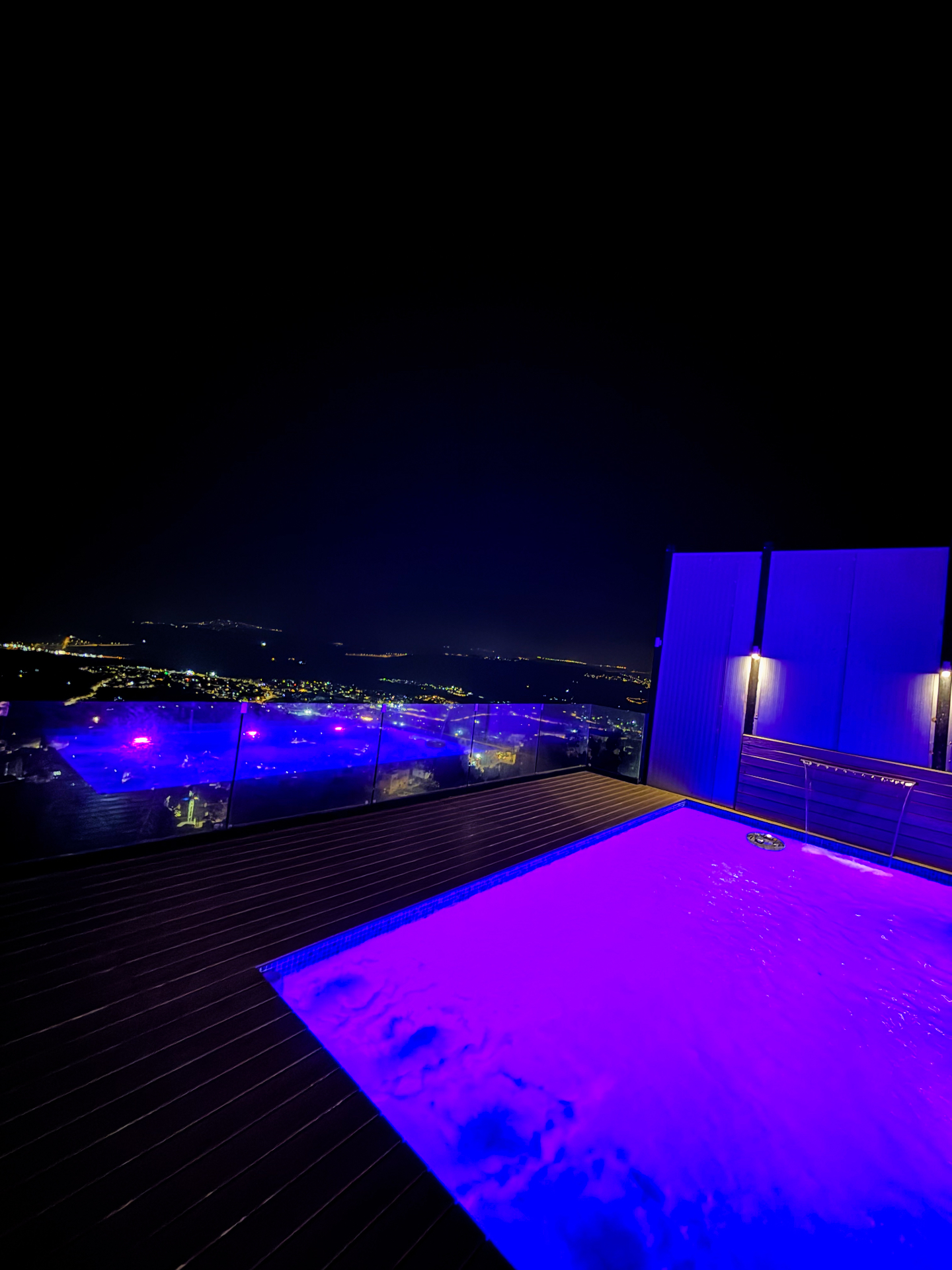 Rooftop pool glowing over city lights